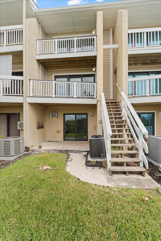 3385 Coastal Hwy Unit 23, Saint Augustine, FL 32084 - back of property with stucco siding, stairway, and a yard