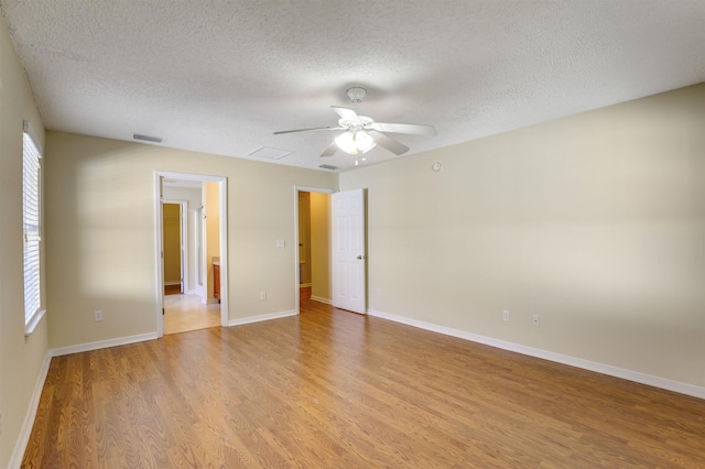 unfurnished bedroom featuring visible vents, a ceiling fan, a textured ceiling, light wood finished floors, and baseboards