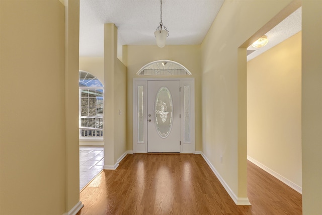 foyer entrance featuring wood finished floors and baseboards