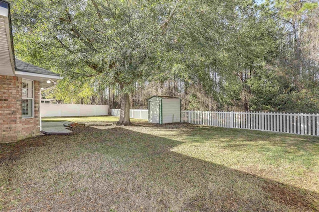 view of yard featuring an outbuilding, a storage shed, and a fenced backyard