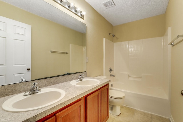 bathroom with a sink, visible vents, toilet, and a textured ceiling