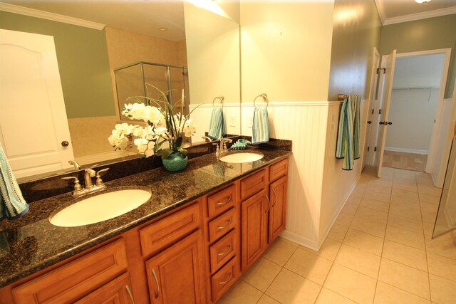 full bath with a sink, tile patterned floors, a stall shower, and crown molding