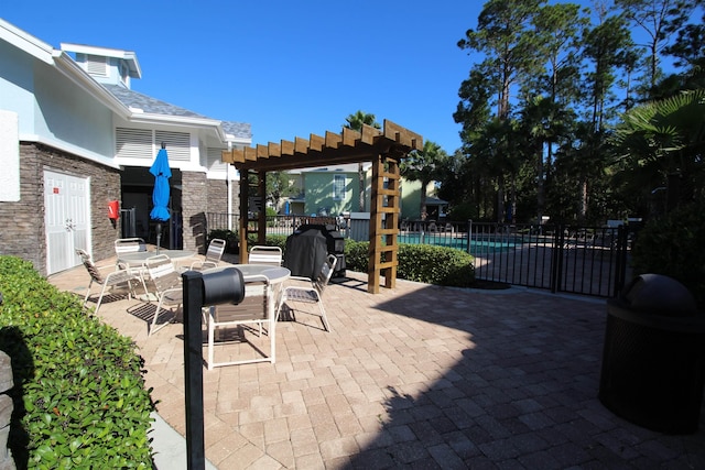 view of patio featuring a pergola, a community pool, a grill, outdoor dining area, and fence