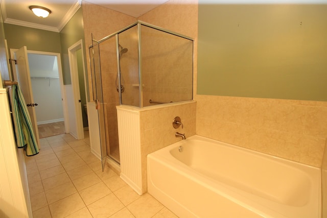 bathroom with a shower stall, tile patterned floors, a bath, and a walk in closet