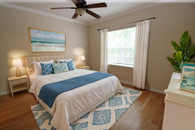 bedroom featuring baseboards, light wood-type flooring, ornamental molding, and ceiling fan