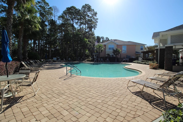 pool featuring fence and a patio