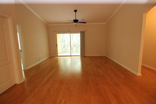 spare room featuring ornamental molding, a ceiling fan, arched walkways, and visible vents
