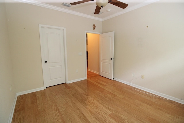 unfurnished bedroom with baseboards, ornamental molding, a ceiling fan, light wood-style floors, and visible vents
