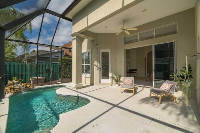 view of swimming pool with pool water feature, a patio, a lanai, and ceiling fan