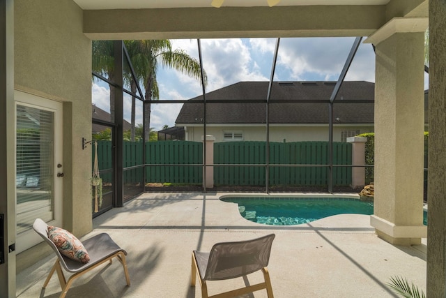 view of swimming pool with a patio area and glass enclosure