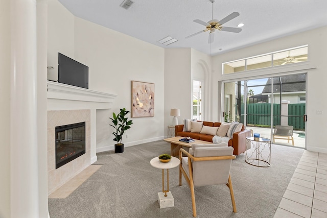 tiled living room featuring a fireplace and ceiling fan