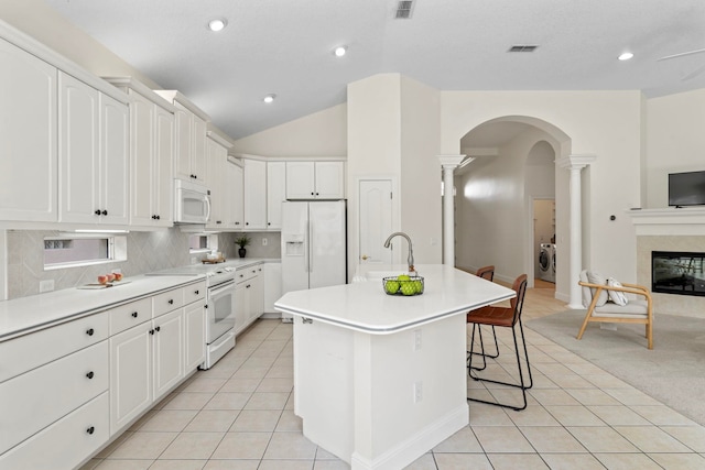 kitchen with sink, white appliances, an island with sink, and white cabinets