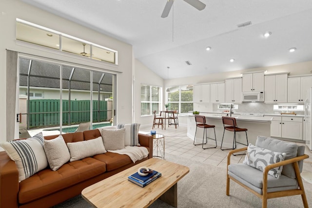 living room featuring light tile patterned flooring, lofted ceiling, and ceiling fan