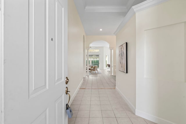 corridor featuring ornate columns, light tile patterned flooring, and ornamental molding