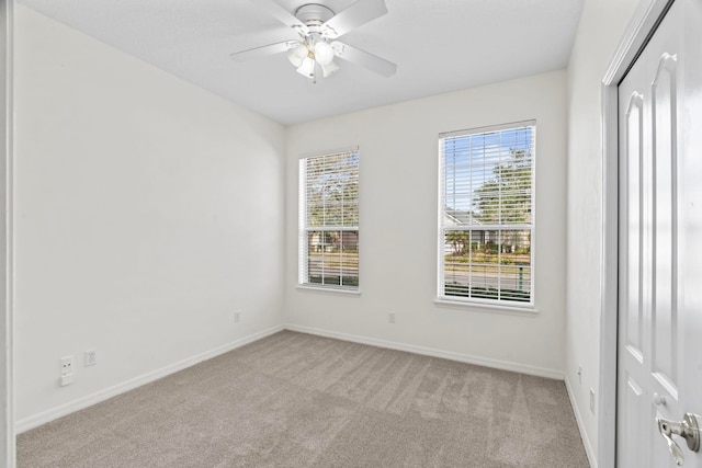 unfurnished room with light colored carpet and ceiling fan