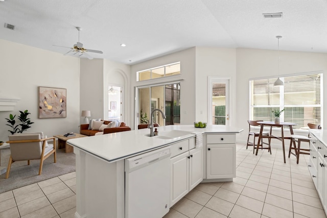 kitchen with sink, a kitchen island with sink, white dishwasher, white cabinets, and light tile patterned flooring