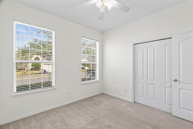 unfurnished bedroom with ceiling fan, light colored carpet, and a closet