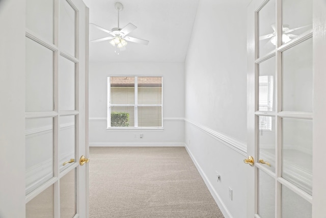 carpeted spare room with ceiling fan and vaulted ceiling