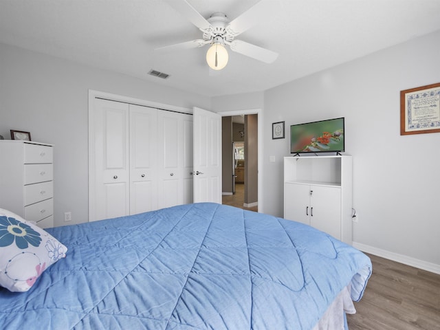 bedroom with hardwood / wood-style floors, ceiling fan, and a closet