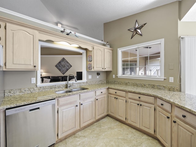 kitchen featuring light brown cabinetry, a textured ceiling, stainless steel dishwasher, and sink