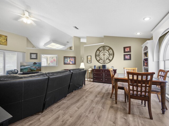 dining room featuring ceiling fan, plenty of natural light, vaulted ceiling, and light wood-type flooring