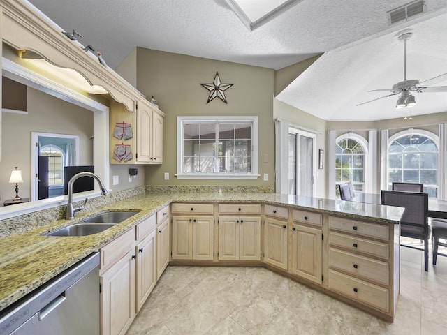 kitchen featuring kitchen peninsula, sink, stainless steel dishwasher, and a textured ceiling