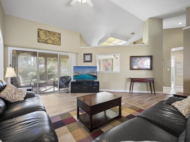 living room with hardwood / wood-style flooring, high vaulted ceiling, and ceiling fan