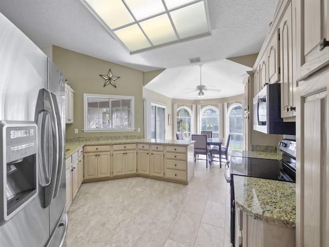 kitchen featuring kitchen peninsula, appliances with stainless steel finishes, a textured ceiling, and ceiling fan