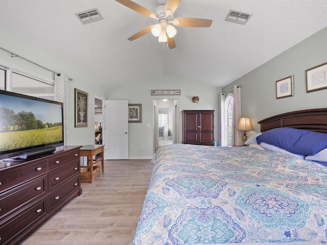 bedroom with ceiling fan, lofted ceiling, and light hardwood / wood-style flooring