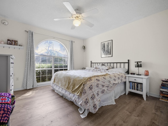 bedroom featuring ceiling fan, dark hardwood / wood-style flooring, and a textured ceiling