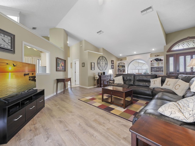 living room featuring high vaulted ceiling and light hardwood / wood-style floors