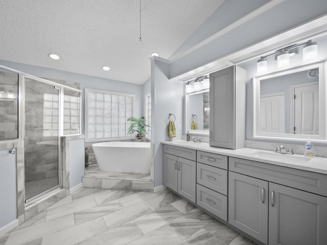 bathroom with vanity, shower with separate bathtub, a textured ceiling, and vaulted ceiling