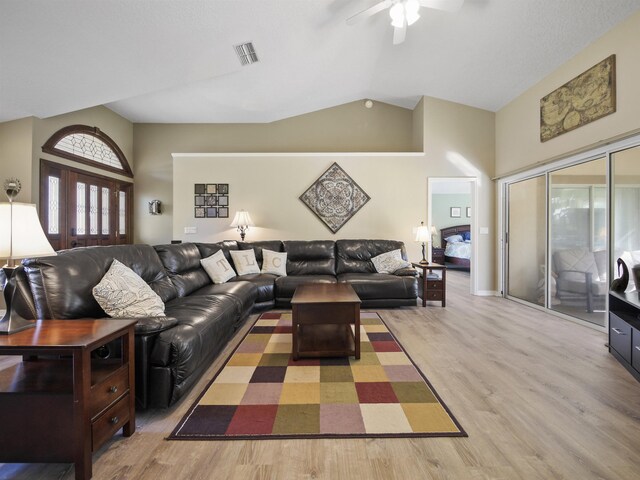 living room featuring ceiling fan, lofted ceiling, and light hardwood / wood-style flooring