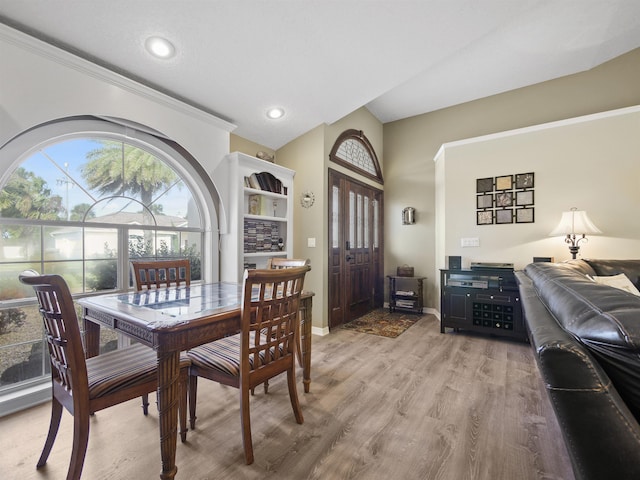 dining area featuring hardwood / wood-style floors and vaulted ceiling