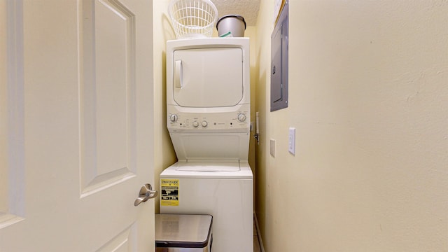 laundry room featuring electric panel and stacked washing maching and dryer