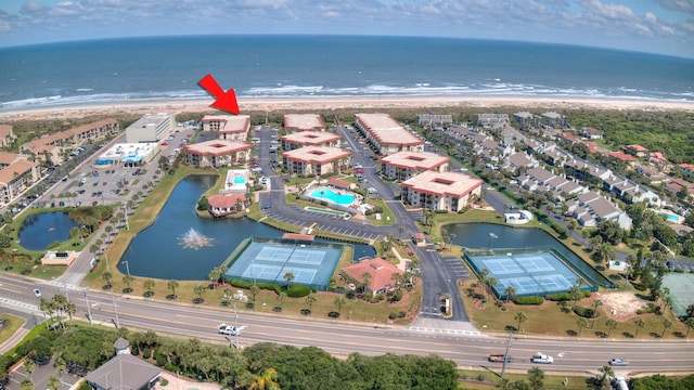 birds eye view of property with a water view and a beach view