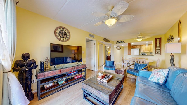 living room featuring light hardwood / wood-style flooring and ceiling fan