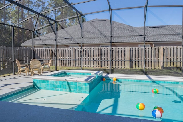 view of pool with an in ground hot tub, a patio, and glass enclosure