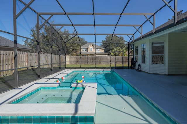 view of swimming pool featuring glass enclosure and a patio