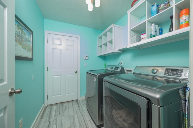 laundry room with washer and clothes dryer and a textured ceiling