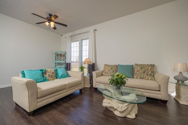 living room featuring a textured ceiling, ceiling fan, and dark wood-type flooring