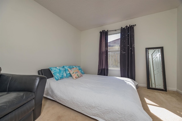 bedroom featuring light colored carpet and vaulted ceiling