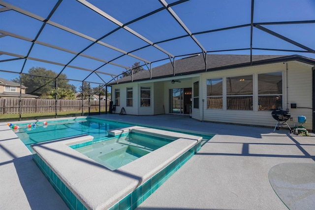 view of swimming pool featuring glass enclosure, ceiling fan, an in ground hot tub, and a patio