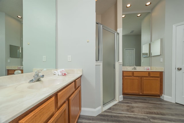 bathroom with hardwood / wood-style floors, vanity, and a shower with door