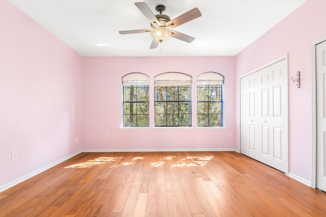 unfurnished bedroom featuring a ceiling fan, light wood-style floors, and baseboards