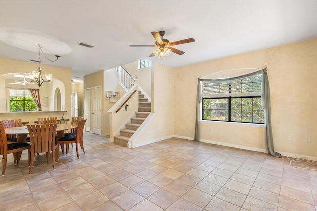 dining room with visible vents, ceiling fan with notable chandelier, stairway, and a healthy amount of sunlight