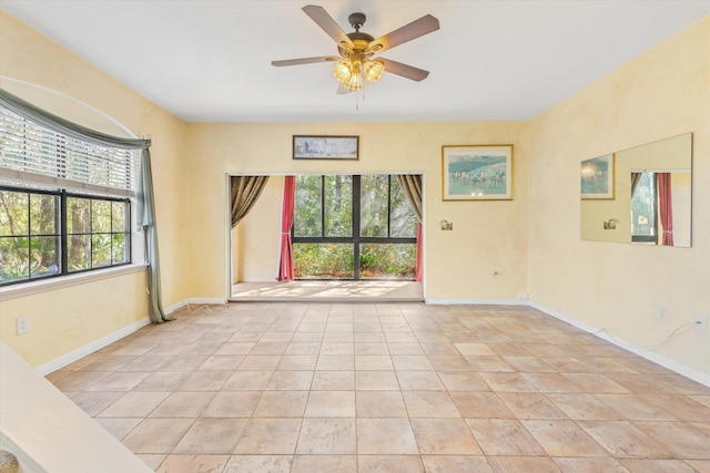 spare room with light tile patterned floors, baseboards, and ceiling fan