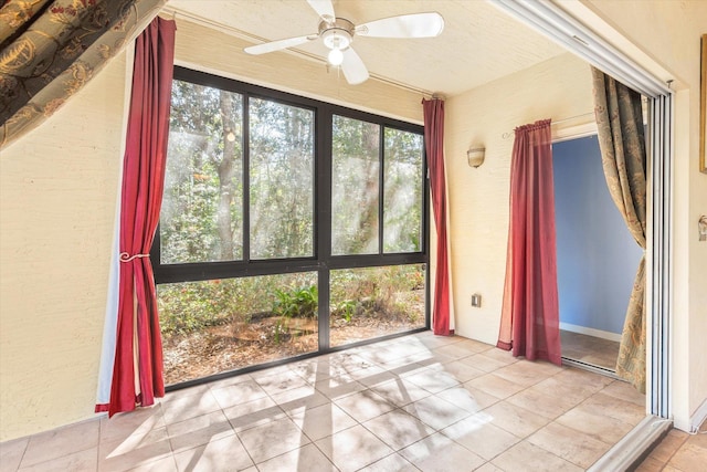 unfurnished sunroom featuring ceiling fan