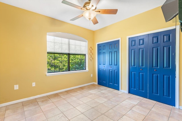 foyer with tile patterned flooring, baseboards, and a ceiling fan