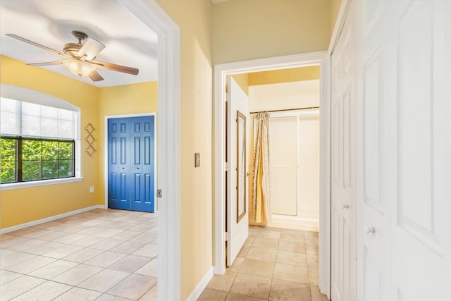 hall with light tile patterned floors and baseboards